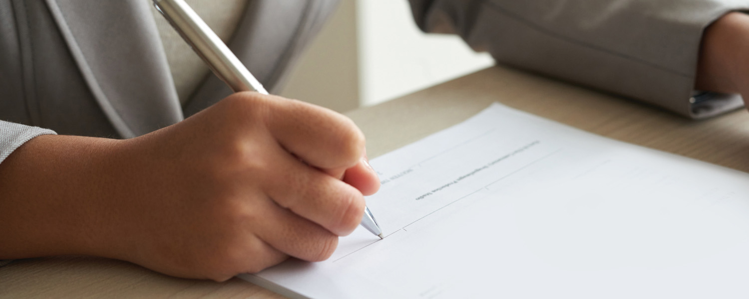 Person completing a form during a JP drop-in service.