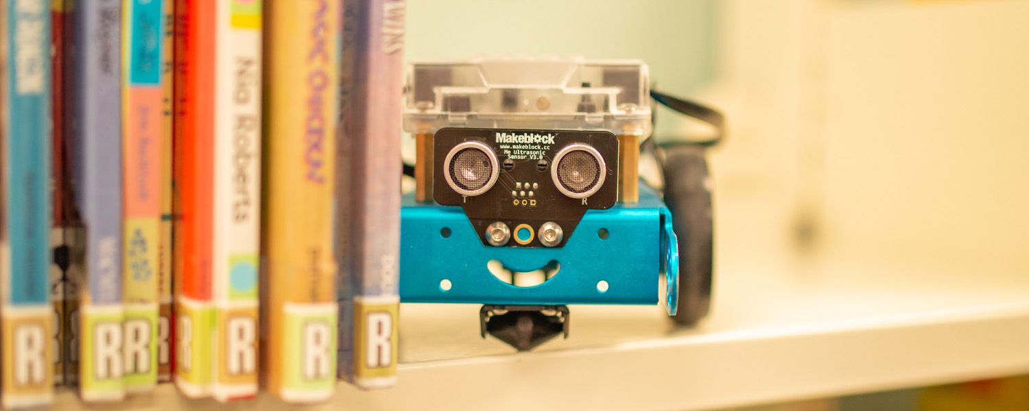 Programmable robot among library books.